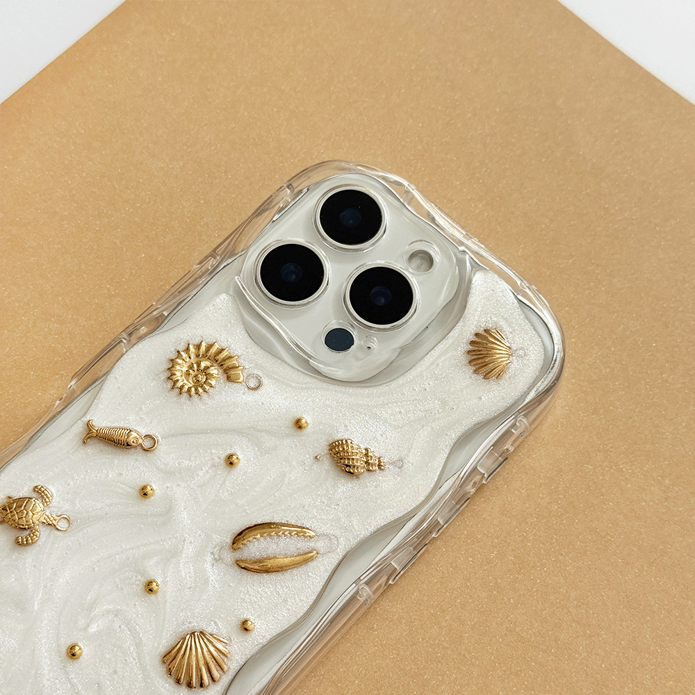 A clear phone case with a white pearlescent background, gold seashell and starfish embellishments, shown on a gold background.