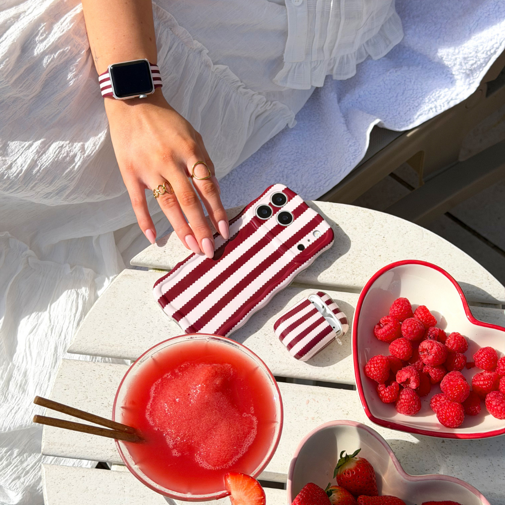 Wavy Blushberry Scallop Stripes Phone Case on a table with berries and strawberry cocktail
