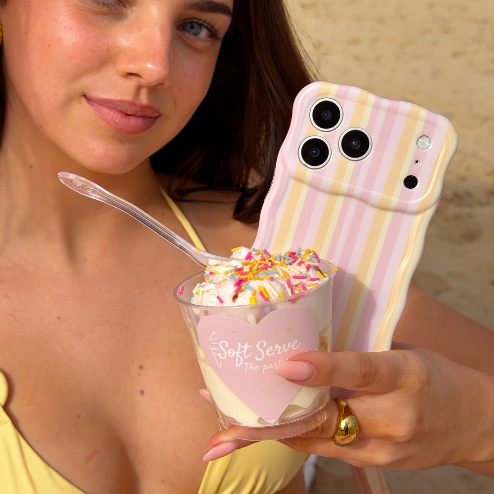 Close up image on the beach with ice cream holding the Wavy Phone Case in Pastel Stripes
