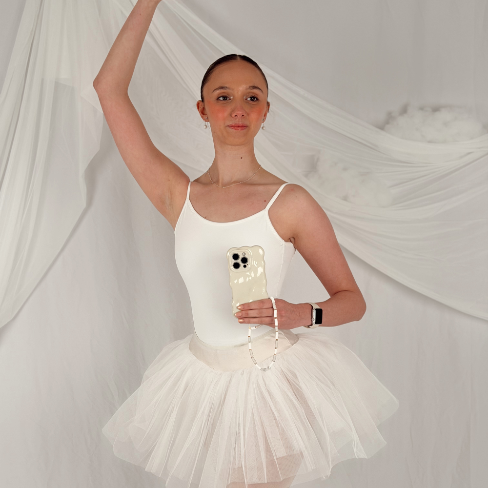 Girl in ballet pose holding the 3D Bubble Phone Case in Cloud Dancer shade