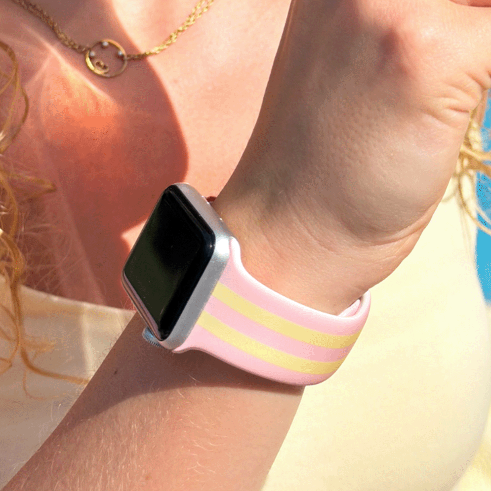 Girl wearing a Apple Watch with pink lemonade watch strap, holding a pink cup.