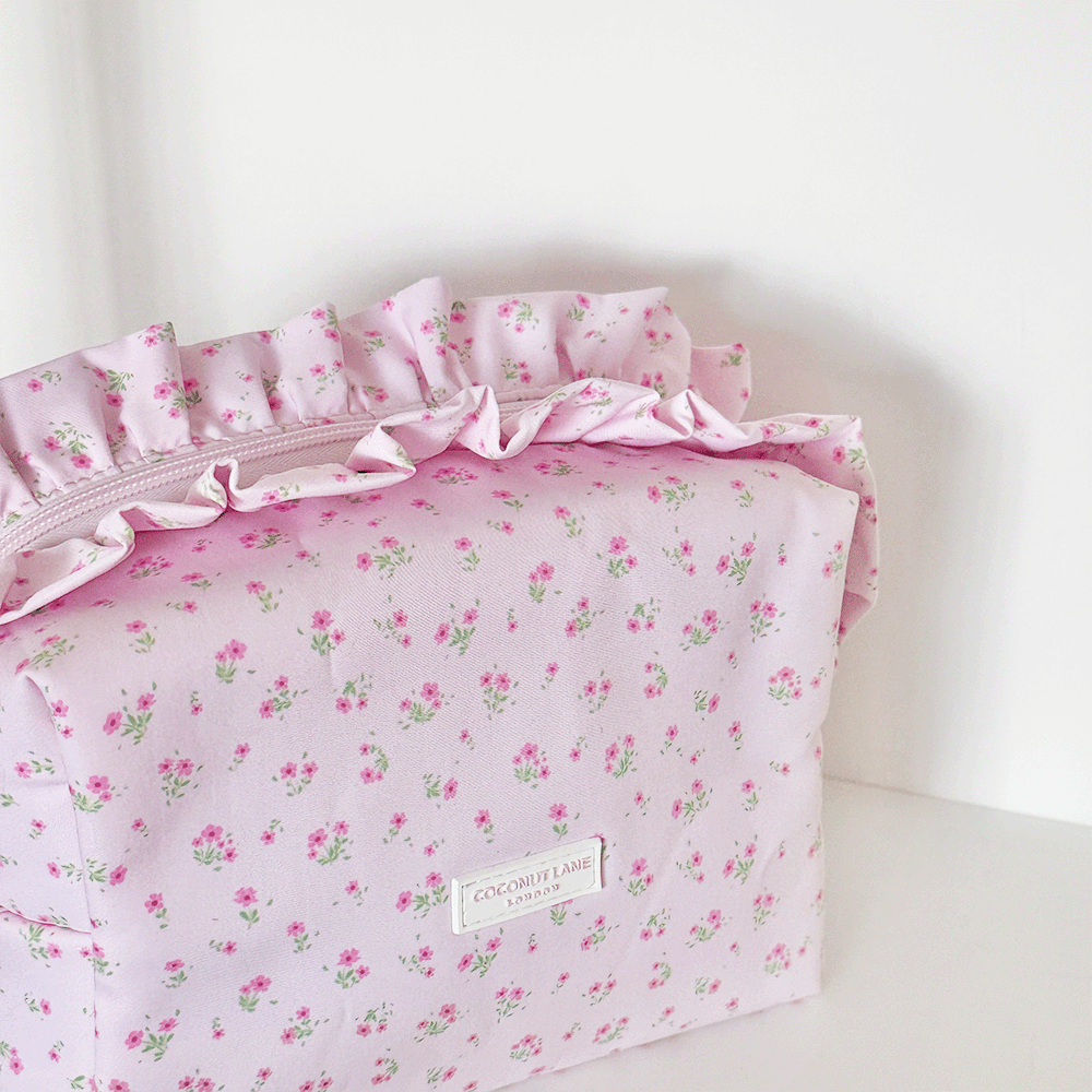Pink floral Makeup Bag with ruffle trim and Coconut Lane logo.