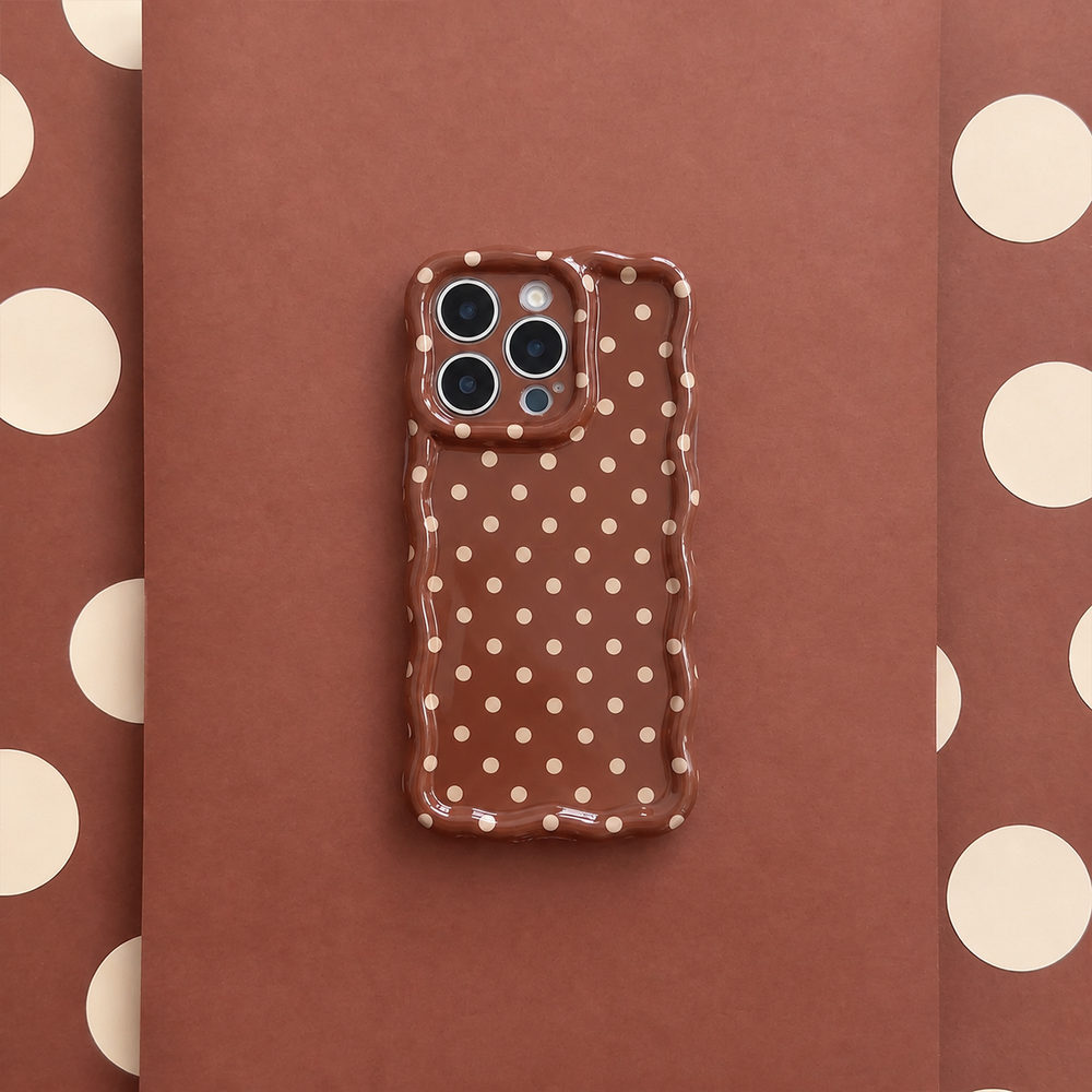 Glossy brown phone case with small cream polka dots and a wavy edge.