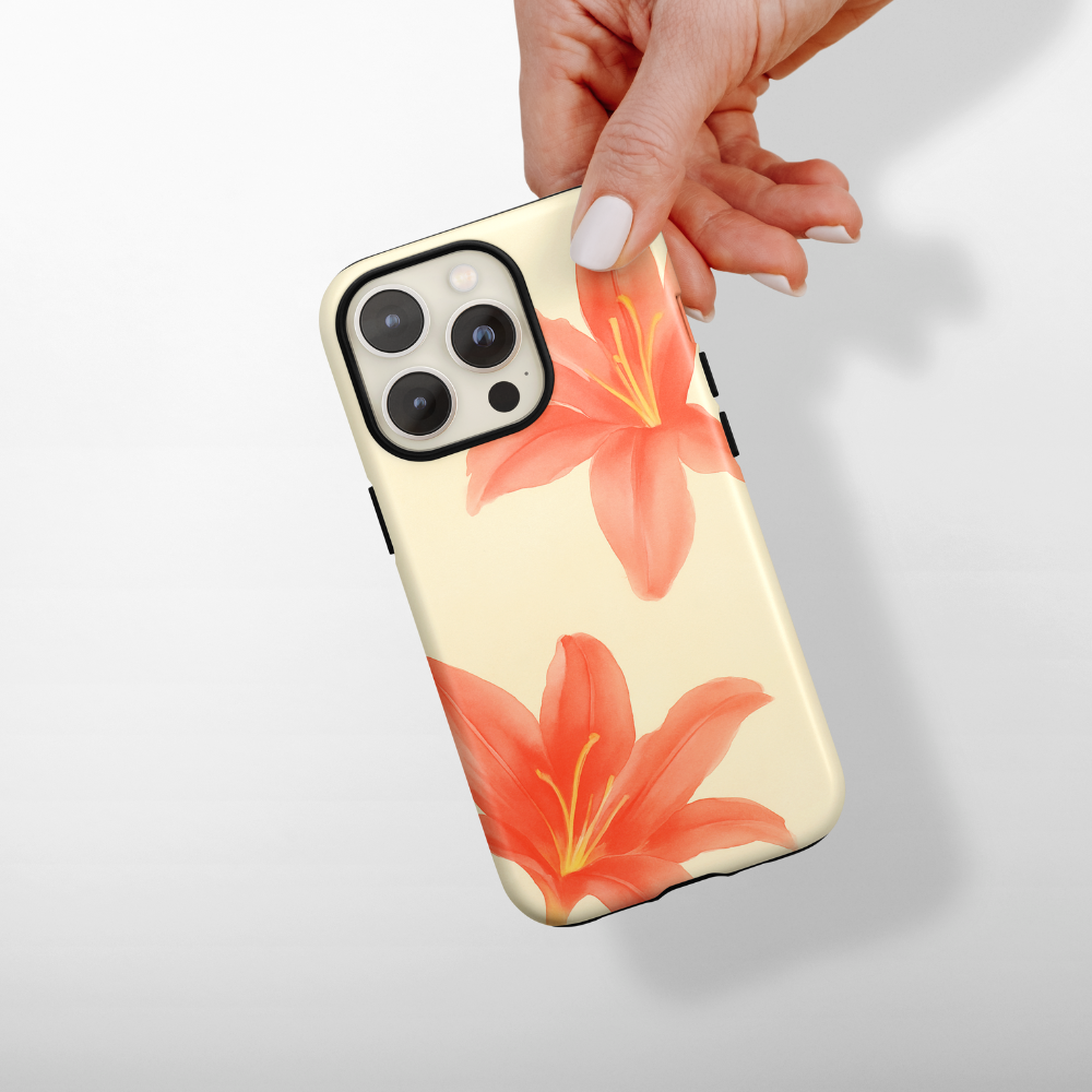 Hand holding a beige Coconut Lane tough phone case with two orange lily flowers.