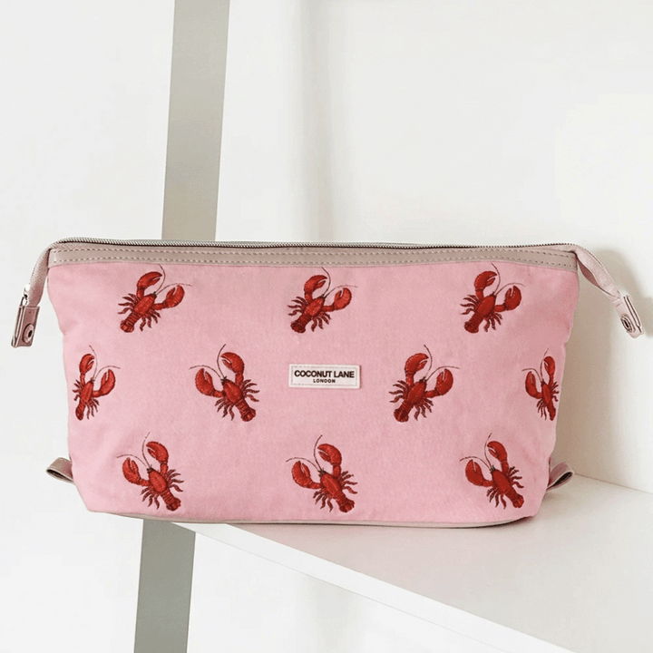 Pink velvet material Makeup Bag with zip closure and Coconut Lane logo. Embroidered with red lobsters.