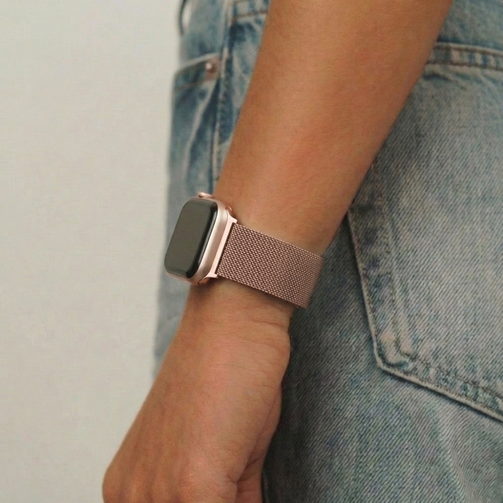 Rose gold Coconut Lane Magnetic Chain Apple Watch Strap worn on wrist, paired with blue jeans.