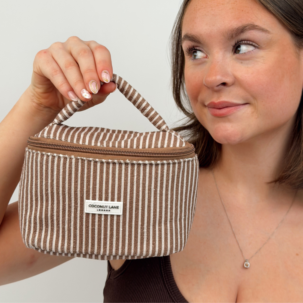 Girl holding mini towel travel vanity case in chestnut stripes