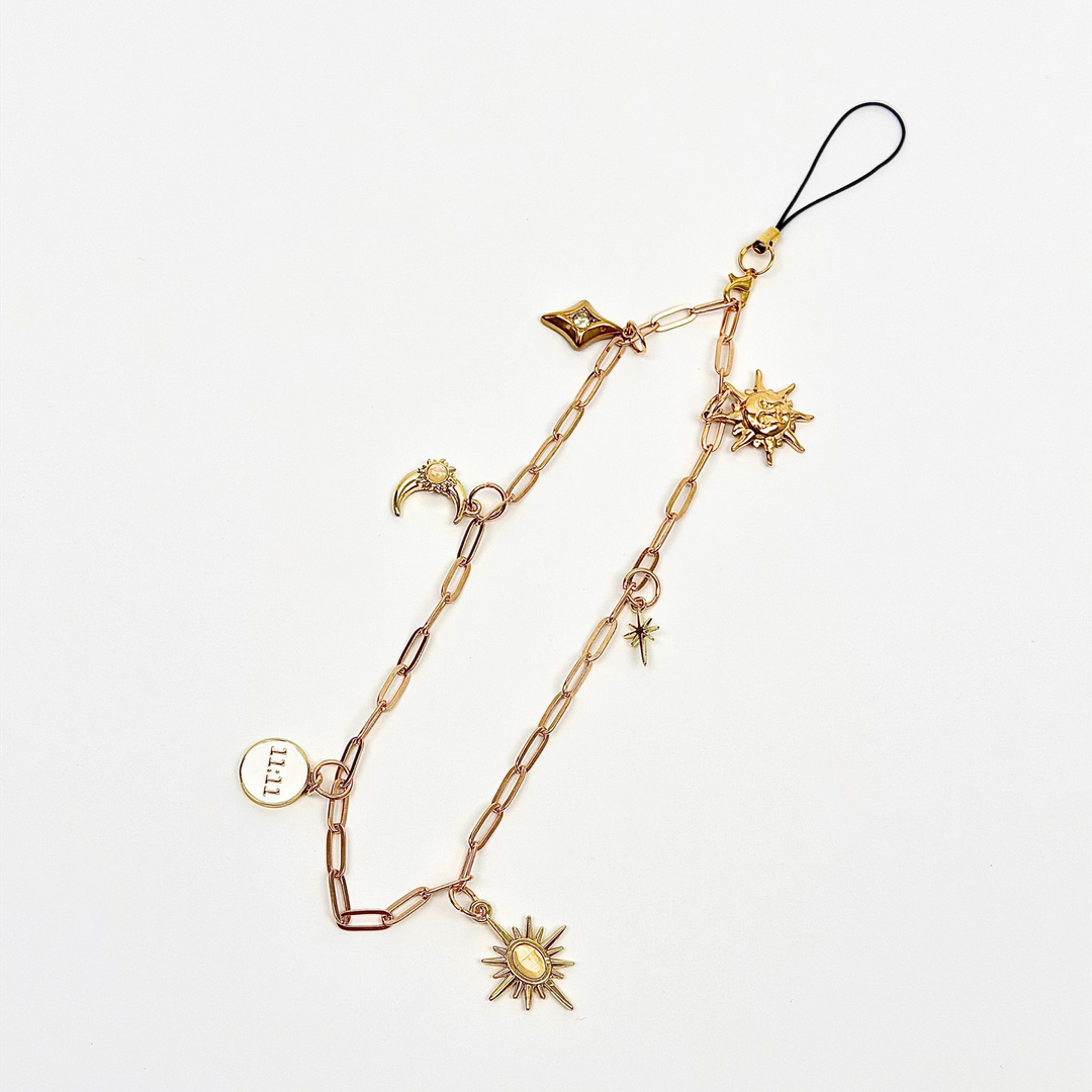 gold colour chain phone strap with celestial style charms, including a moon, sun, star, diamond shape and 11:11 charm. 