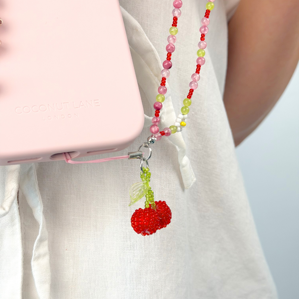 beaded cherry bomb phone strap attached to pink phone case