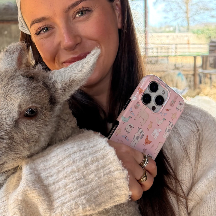 girl holding lamb and countyside cuties tough phone case in hand