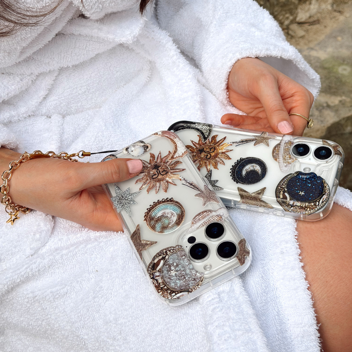 Girl holding pastel and celestial phone case wearing white dressing gown
